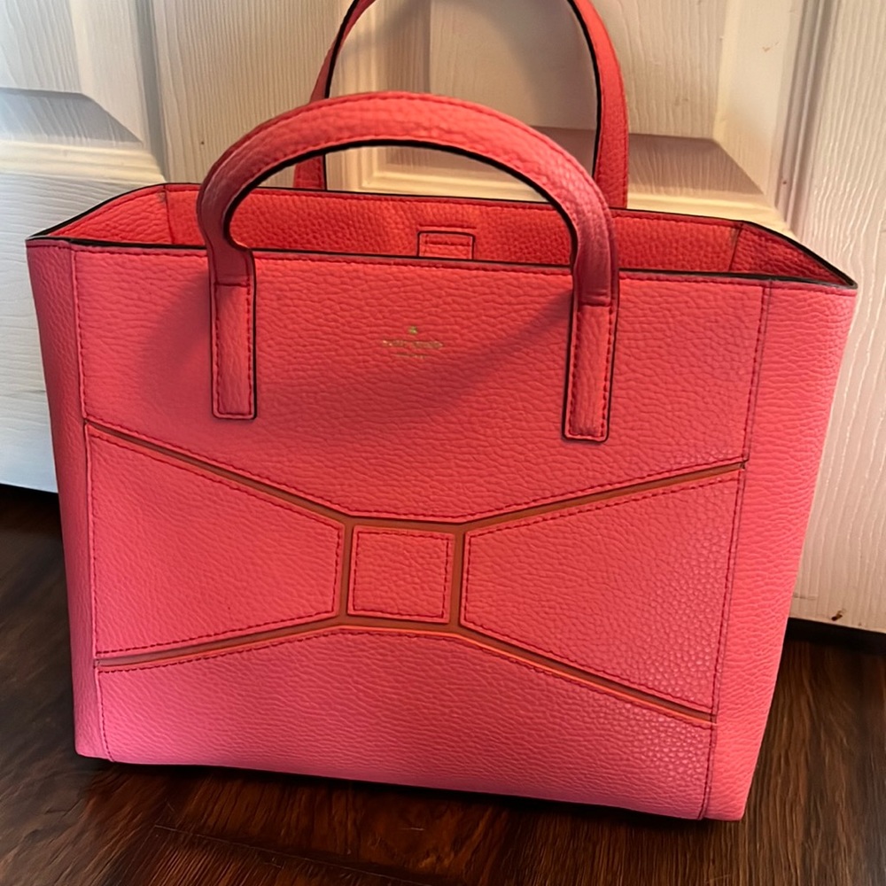 Cute Kate Spade bag with bow tie design. Two interior pockets and one that zips.